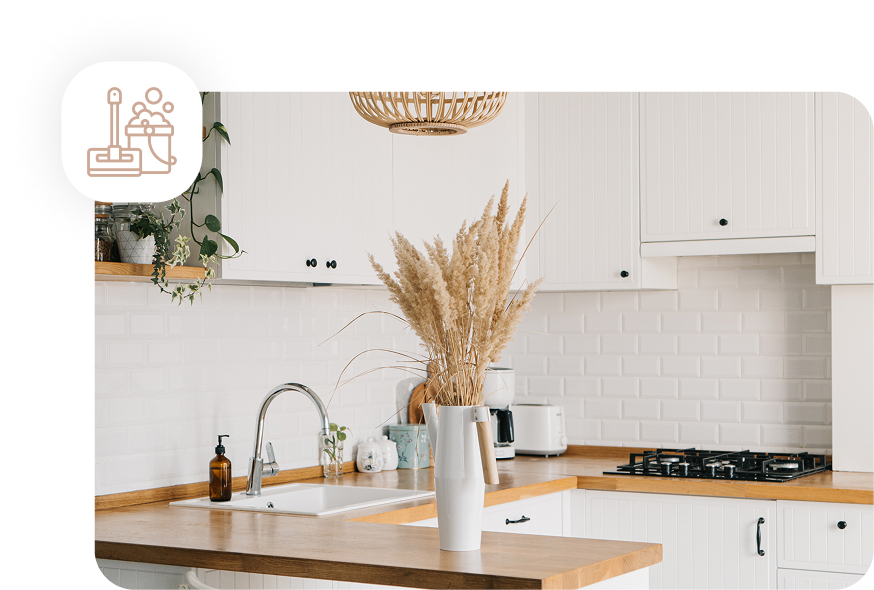 A pristine and bright kitchen with white cabinets, a wooden countertop, and a clean sink, showcasing the result of a deep cleaning service.