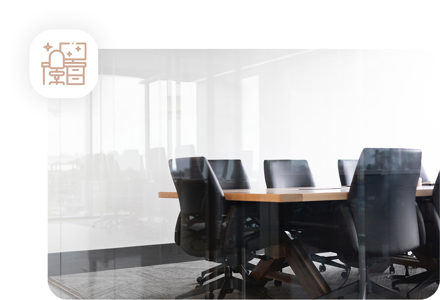 A modern and clean office conference room with a wooden table and black chairs, viewed through a clear glass wall, illustrating office cleaning.