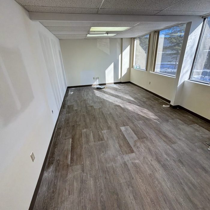 Empty commercial office space with clean and gleaming floors, showcasing an office cleaning service.